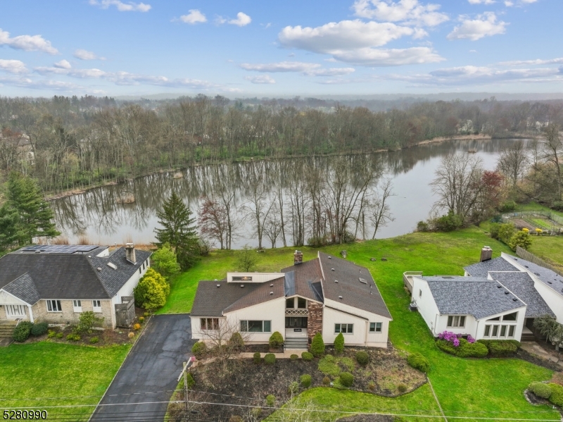 an aerial view of a house with garden space and a lake view