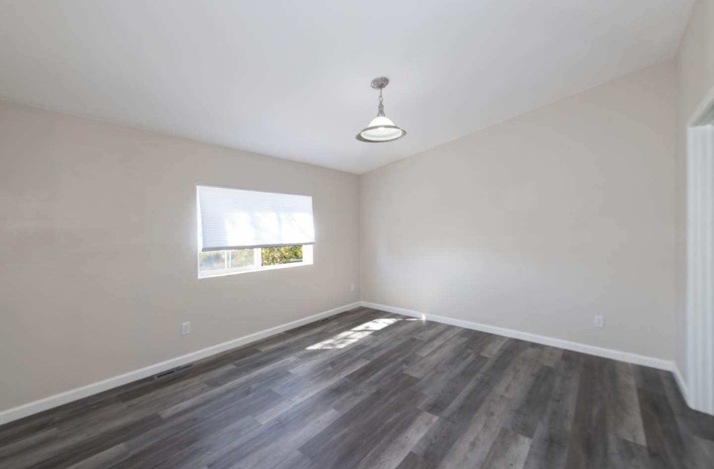 163 Harkins Slough Road Watsonville, CA 95076 - Photo 12 of 21 an empty room with wooden floor and windows