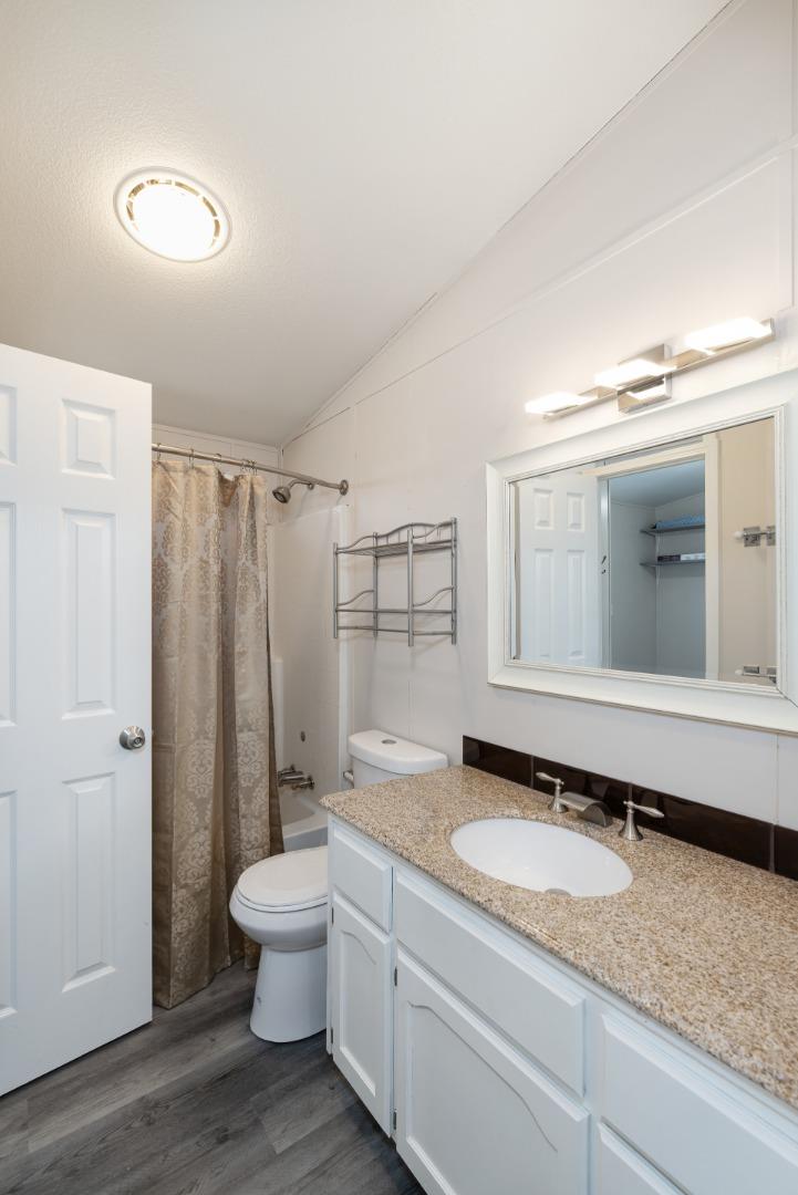 163 Harkins Slough Road Watsonville, CA 95076 - Photo 16 of 21 a bathroom with a granite countertop sink toilet and shower