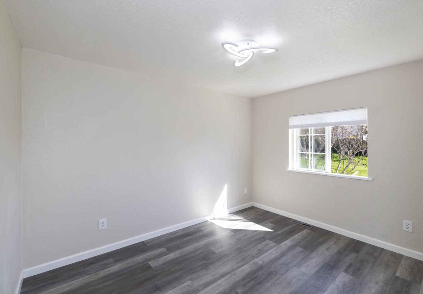 163 Harkins Slough Road Watsonville, CA 95076 - Photo 17 of 21 a view of an empty room with wooden floor and a window
