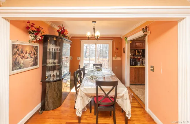 a dining room with furniture a chandelier and wooden floor