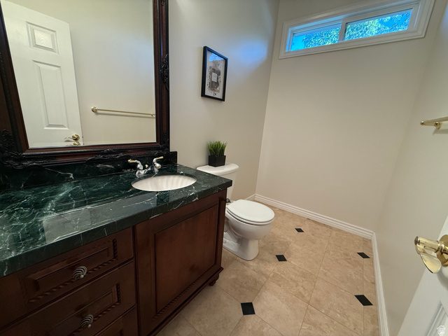 1562 Fairway Ridge Road Draper, UT 84020 - Photo 34 of 60 Bathroom vanity featuring a dark wood cabinet with decorative drawer pulls, a green marbled countertop, and an undermount sink with chrome fixtures