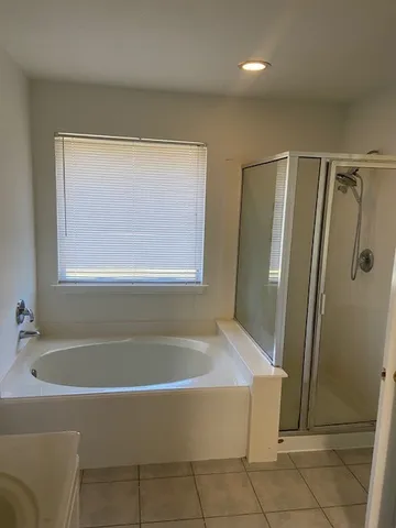 a white bath tub sitting next to a shower