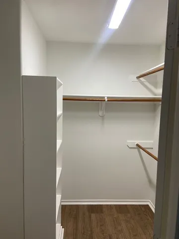 a view of walk in closet with empty racks