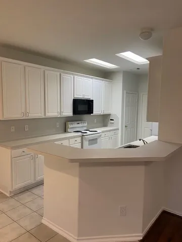 a kitchen with stainless steel appliances white cabinets and a sink