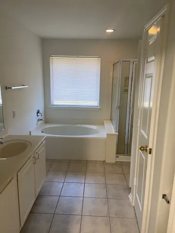 a bathroom with a granite countertop bathtub sink and mirror