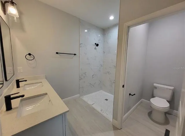 a bathroom with a sink a toilet and shower