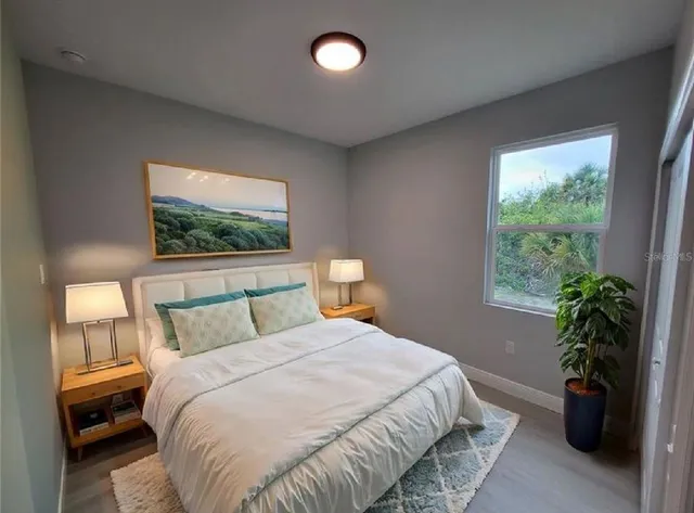 a bedroom with a bed and a potted plant