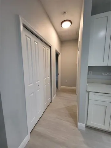 a view of a hallway with closet and wooden floor