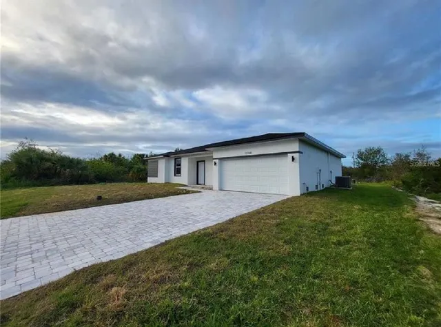 a yellow house with green field in front of it