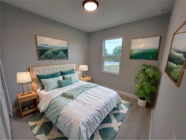 a bedroom with a bed and a potted plant