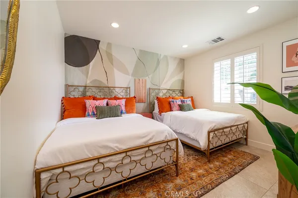 a bedroom with a bed a mirror and dresser