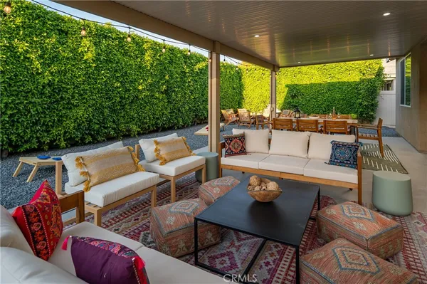 a view of a patio with couches table and chairs and potted plants