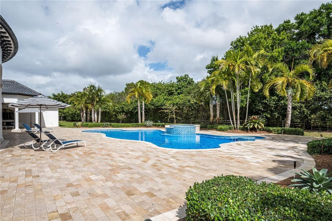 5780 Southwest 128th Avenue Southwest Ranches, FL 33330 - Photo 28 of 80 a view of a swimming pool with lawn chairs under an umbrella