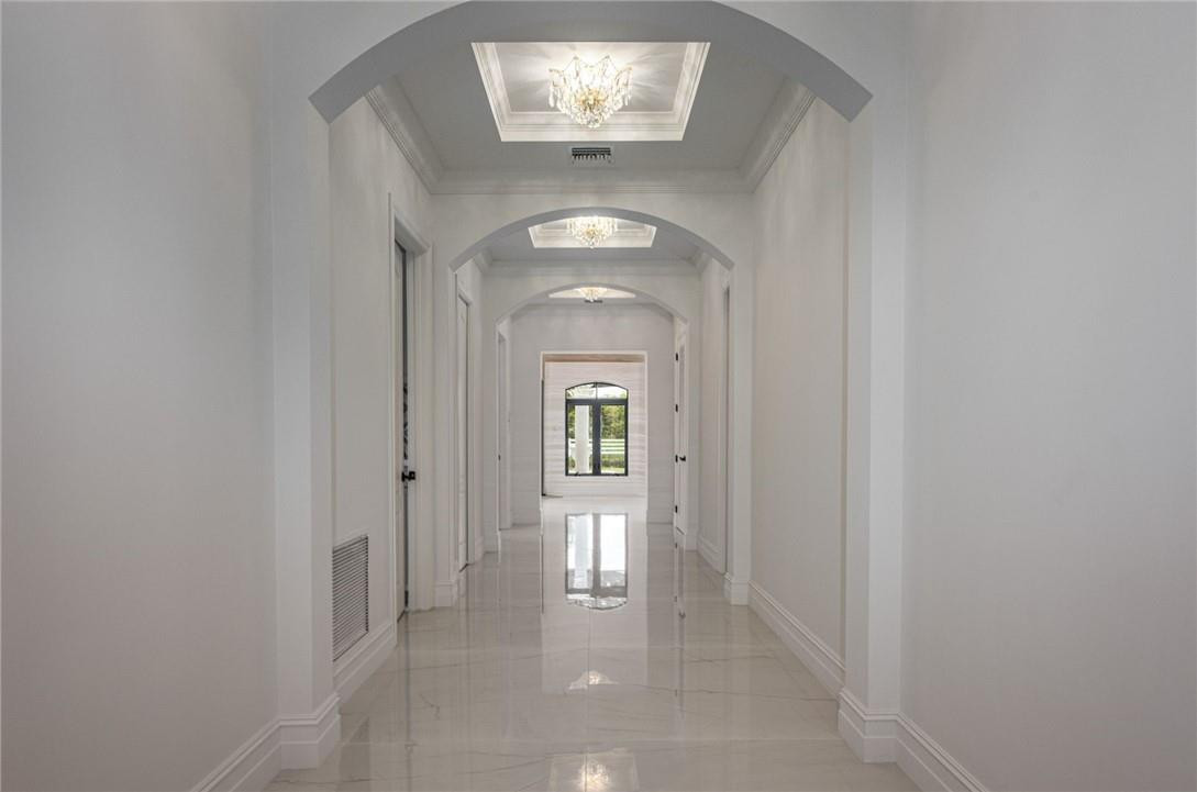 5780 Southwest 128th Avenue Southwest Ranches, FL 33330 - Photo 66 of 80 a view of a hallway with wooden floor and a chandelier
