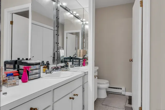a bathroom with a sink vanity mirror and toilet