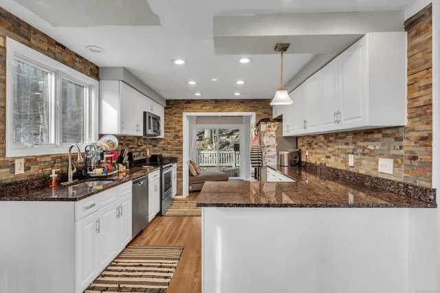 a kitchen with sink a counter top space cabinets and stainless steel appliances
