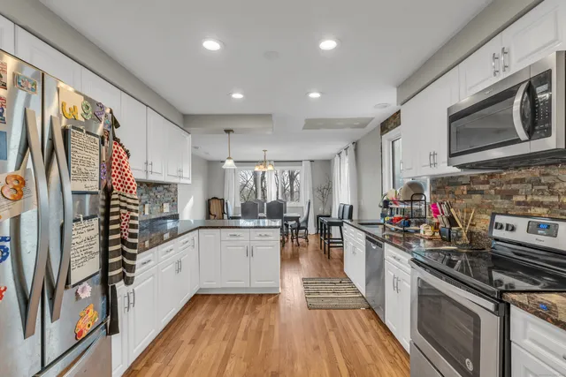 a kitchen with stainless steel appliances a sink dishwasher stove refrigerator and cabinets