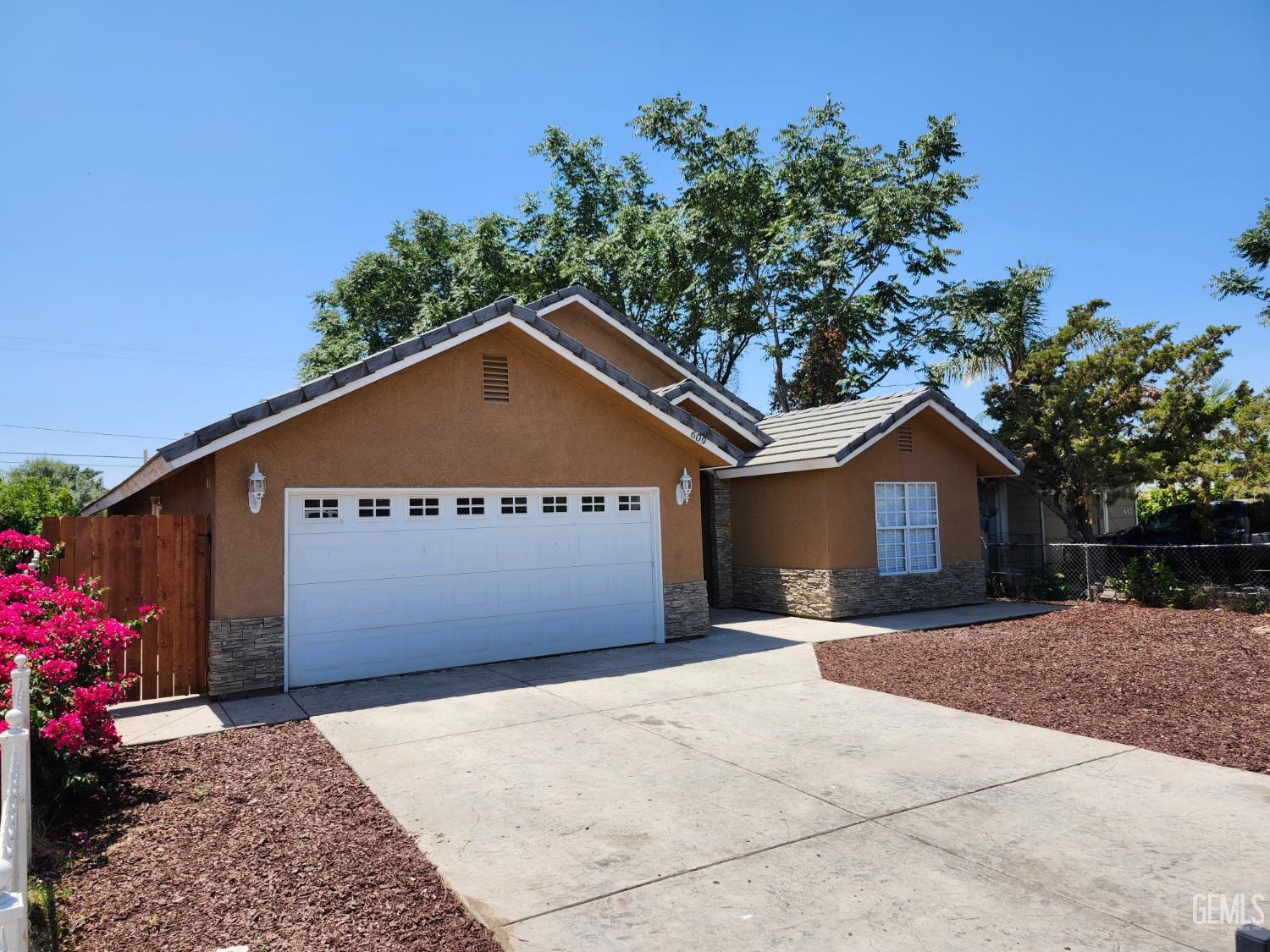 Undisclosed Address Delano, CA 93215 - Photo 2 of 33 a front view of a house with a yard and garage