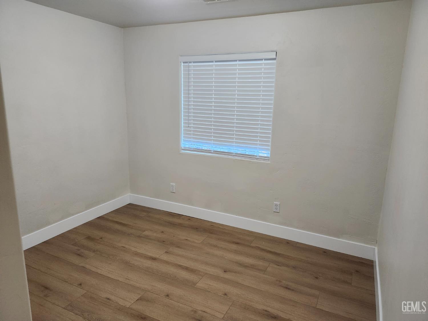 Undisclosed Address Delano, CA 93215 - Photo 22 of 33 wooden floor in an empty room with a window
