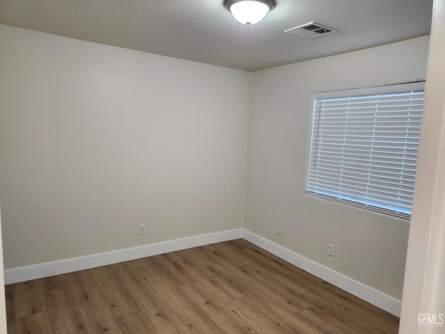 Undisclosed Address Delano, CA 93215 - Photo 25 of 33 wooden floor in an empty room with a window