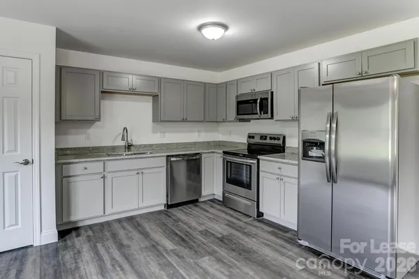 a kitchen with a refrigerator and a stove top oven