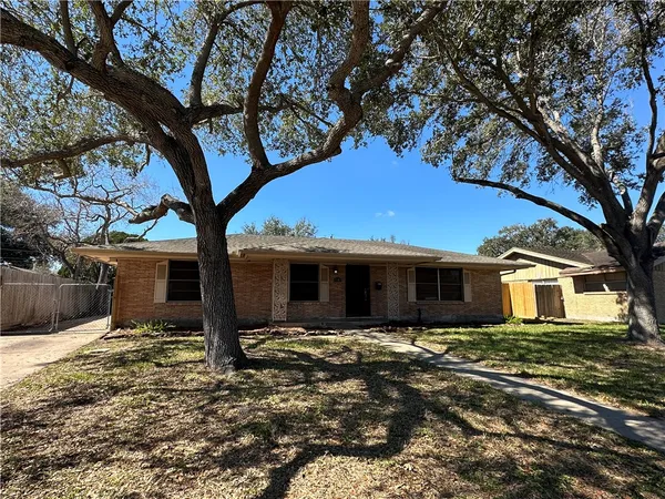 a front view of house with yard and trees around