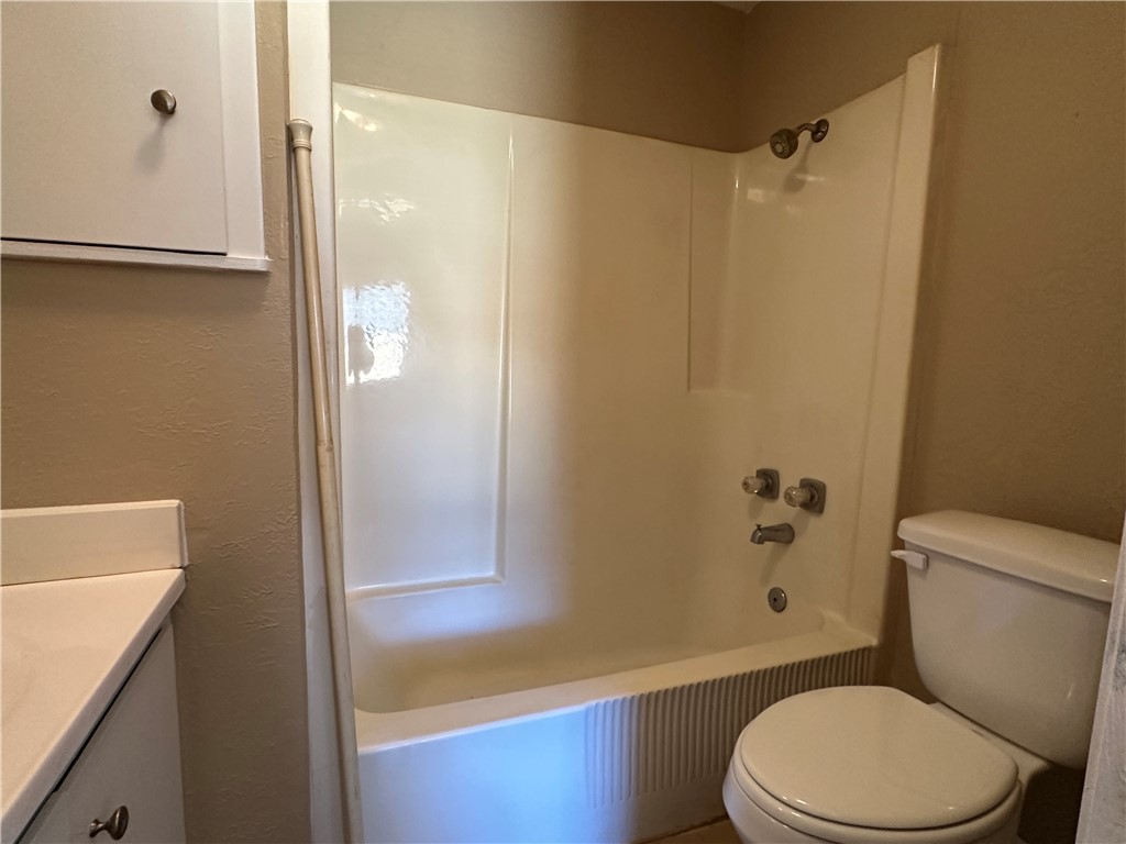 4705 Wooldridge Road Corpus Christi, TX 78413 - Photo 13 of 16 a white toilet sitting next to a bath tub