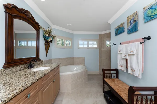 a bathroom with a granite countertop bathtub shower sink and mirror