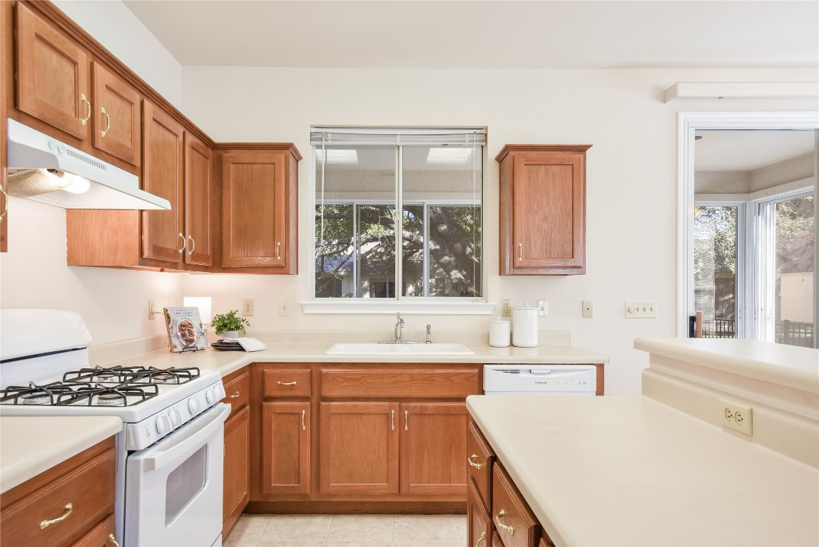 112 Anemone Way Georgetown, TX 78633 - Photo 13 of 40 a kitchen with granite countertop a sink stove and cabinets