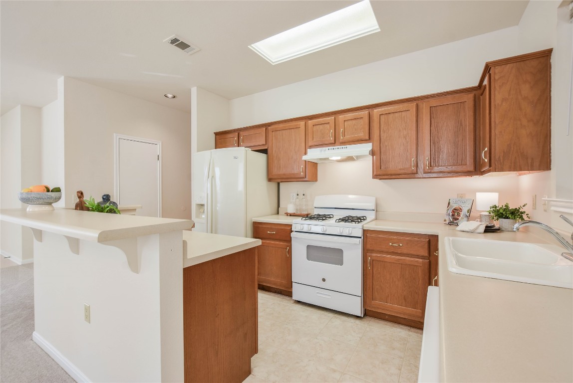112 Anemone Way Georgetown, TX 78633 - Photo 4 of 40 a kitchen with stainless steel appliances a stove a sink a refrigerator a white cabinets and wooden floor