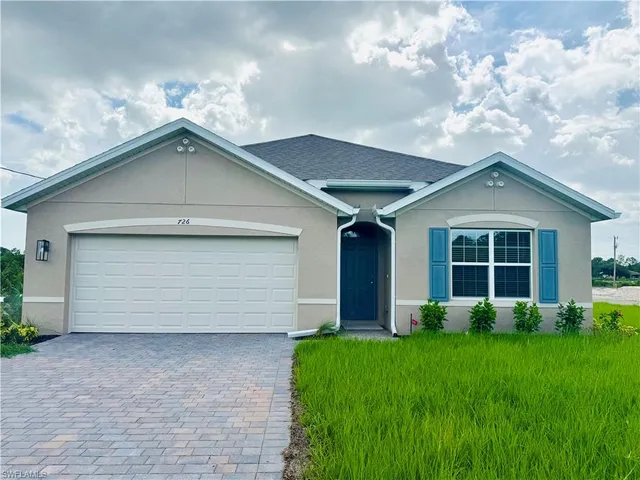 a front view of a house with a garden and yard