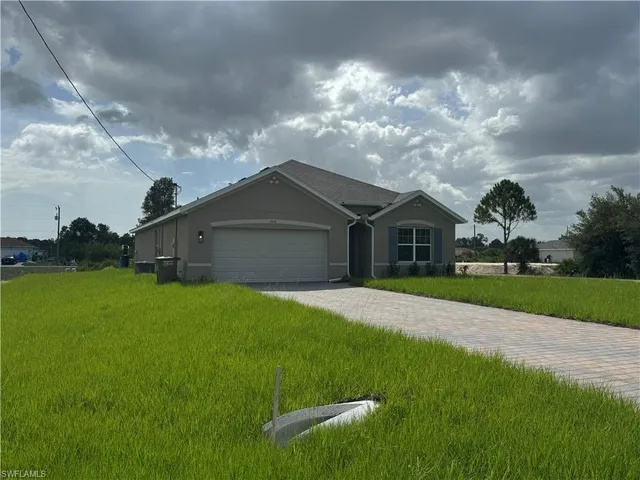 a front view of a house with a yard and garage