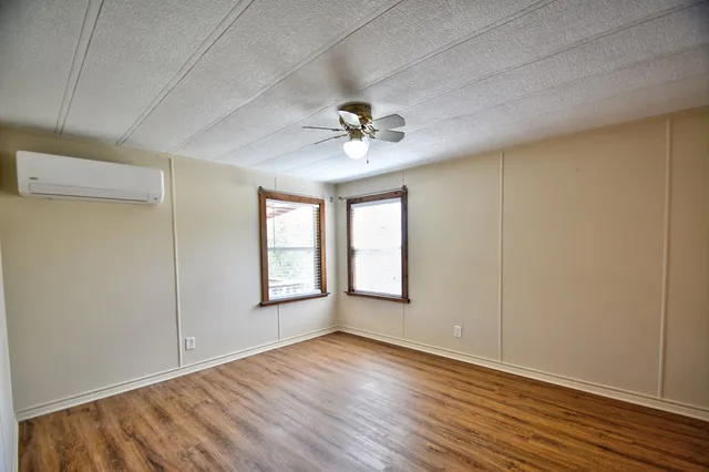 a view of a room with wooden floor and window