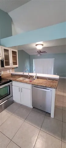 a kitchen with granite countertop a stove a sink and a microwave
