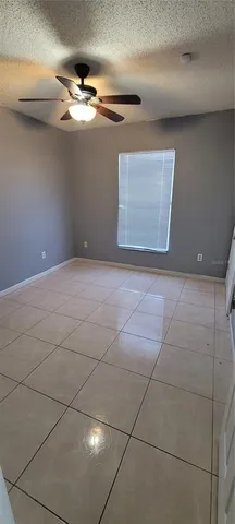 an empty room with windows and fan