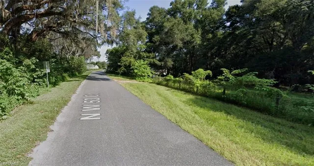 a view of a street with a houses in the background