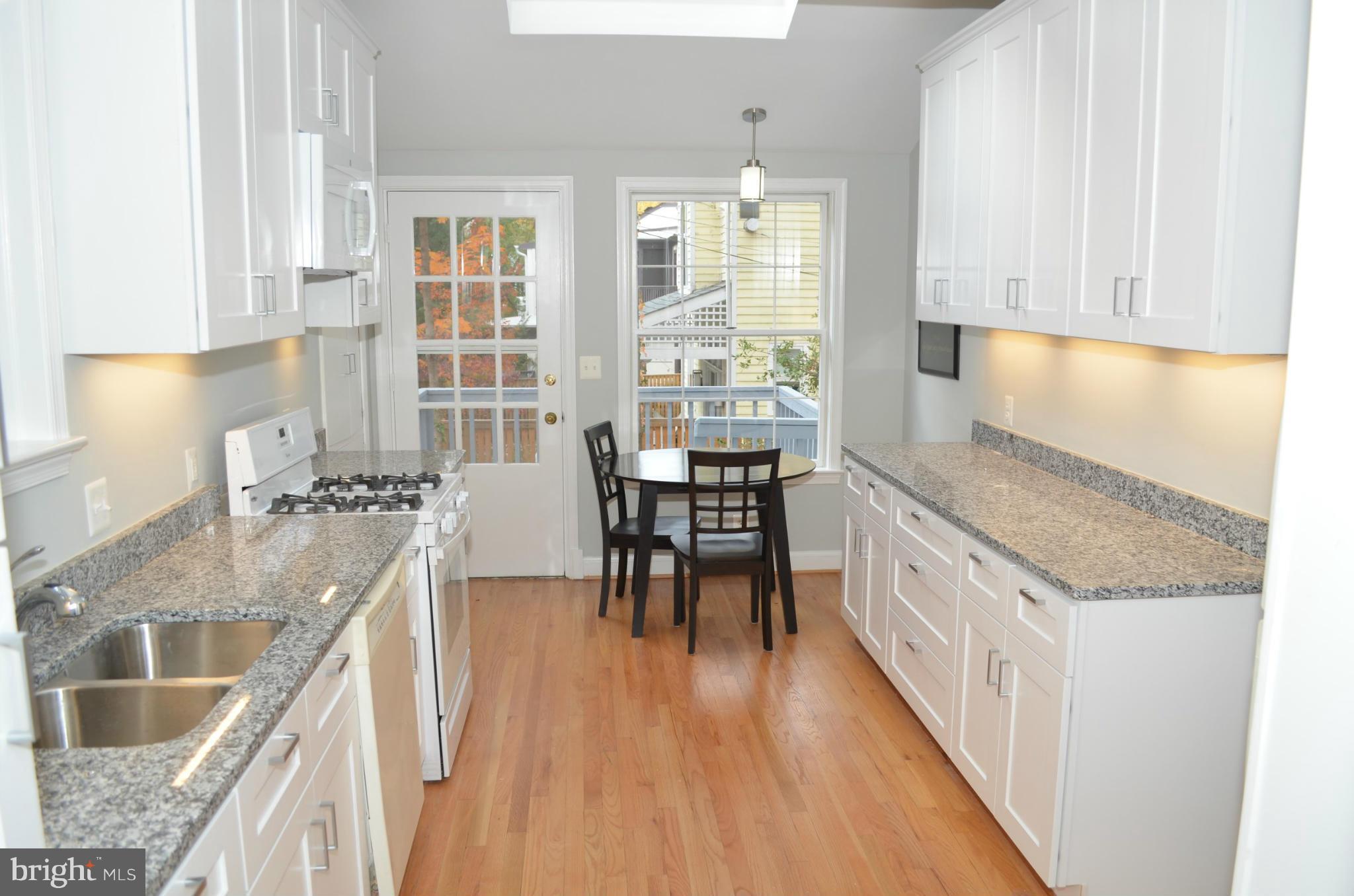 3134 38th Street Northwest Washington, DC 20016 - Photo 7 of 30 a kitchen with granite countertop dining table chairs and a large window