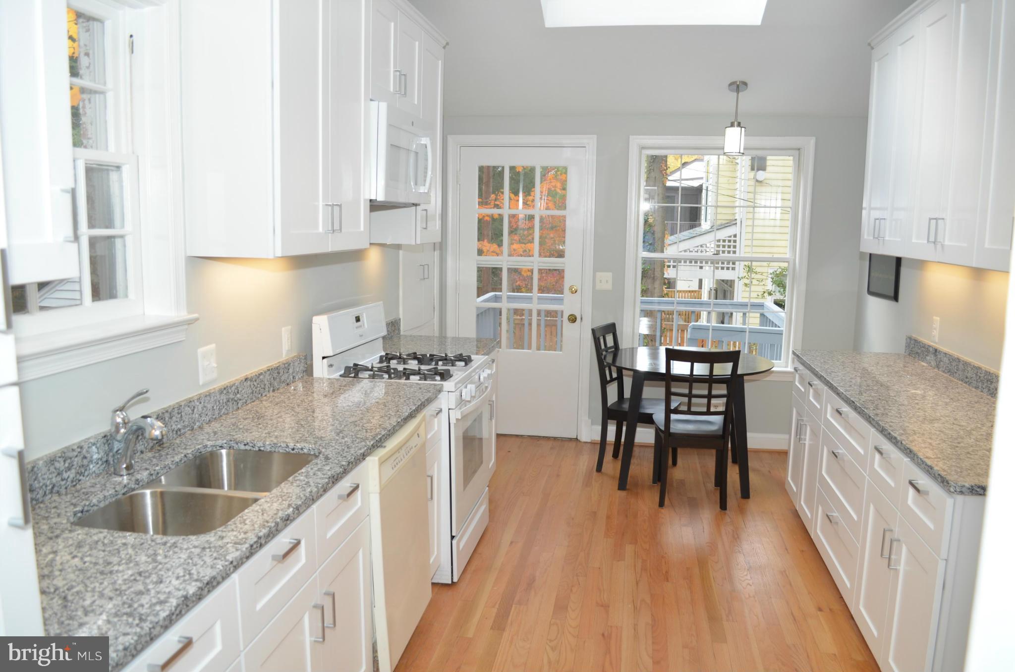 3134 38th Street Northwest Washington, DC 20016 - Photo 8 of 30 a kitchen with counter top space a sink wooden floor and stainless steel appliances