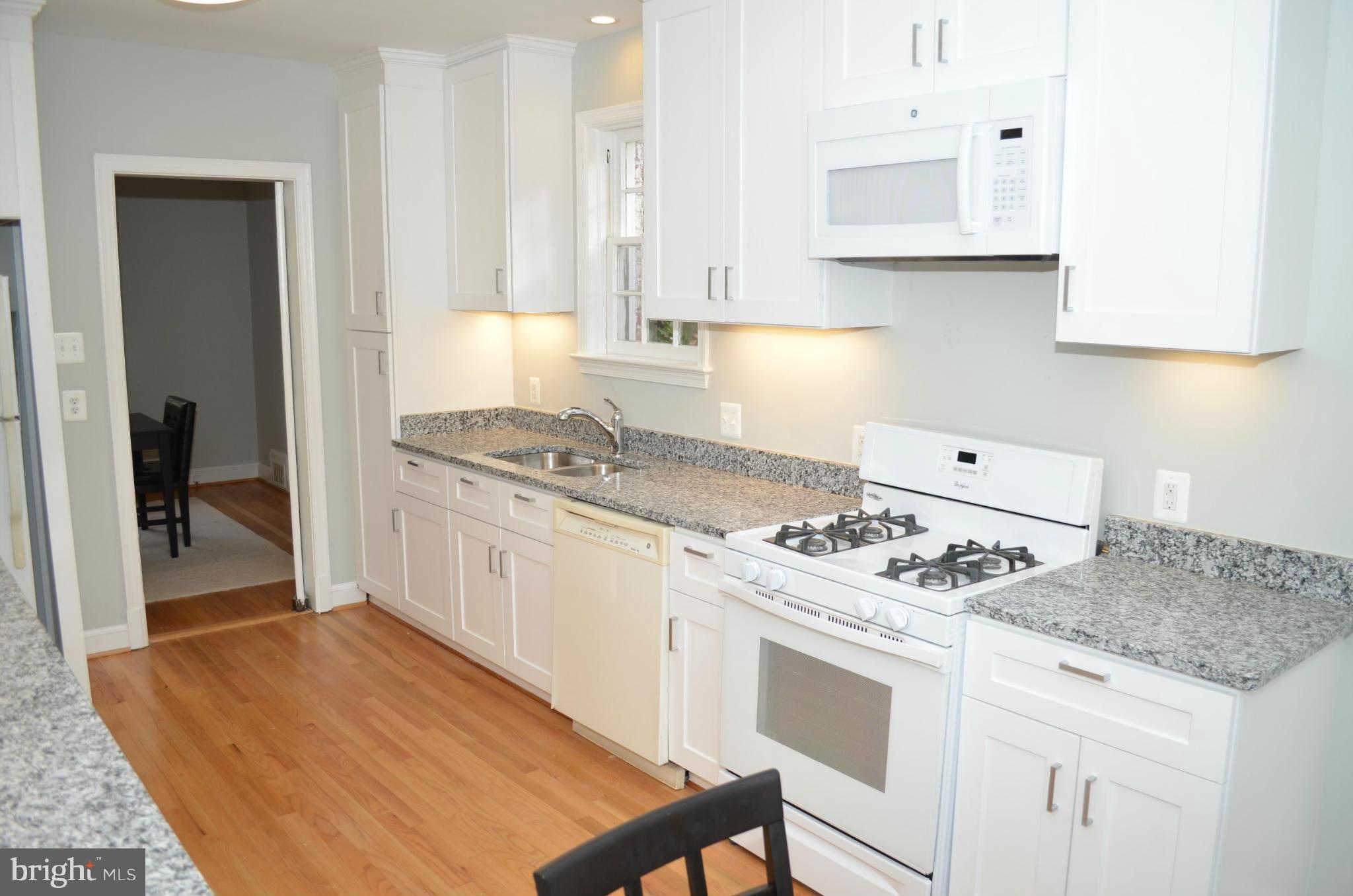 3134 38th Street Northwest Washington, DC 20016 - Photo 9 of 30 a kitchen with stainless steel appliances granite countertop a stove top oven a sink a counter space and cabinets