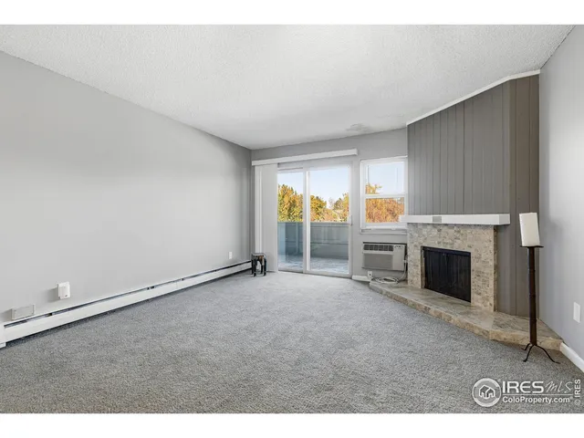 an empty room with fireplace and windows