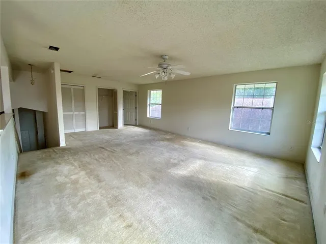 an empty room with windows and closet