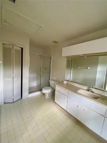 a spacious bathroom with a double vanity sink a toilet and a shower