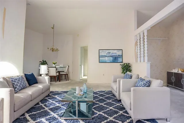 a living room with furniture and a dining table with wooden floor