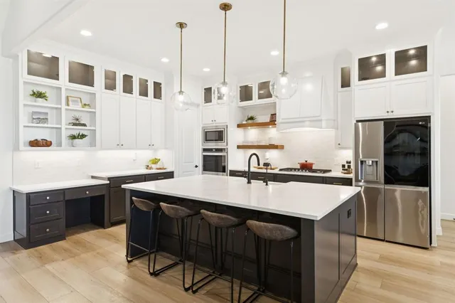 a kitchen with a sink a counter space appliances and cabinets