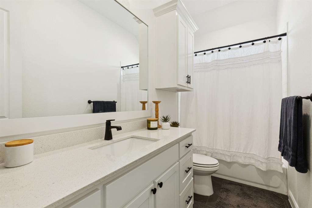 125 San Miguel Drive Decatur, TX 76234 - Photo 15 of 36 a bathroom with a sink a toilet and a mirror