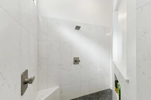 a spacious bathroom with a sink double vanity granite tub shower and a mirror