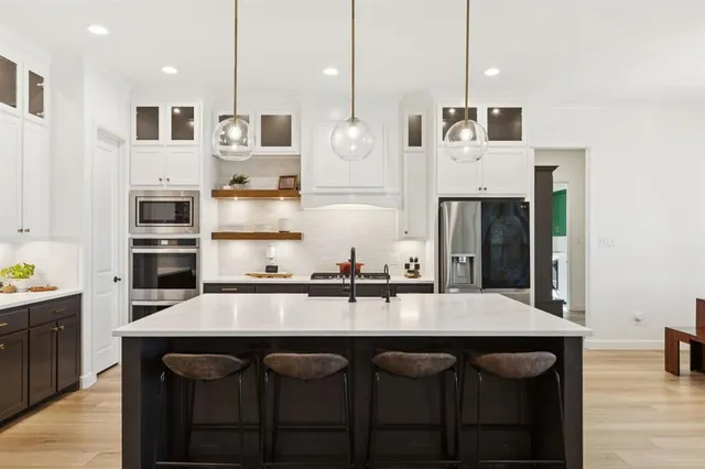 a kitchen with stainless steel appliances granite countertop a sink a stove and a refrigerator