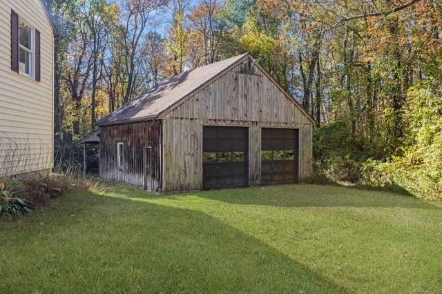 a view of a house with a yard and large tree