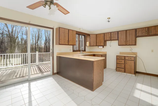 a kitchen with a stove a sink and a refrigerator with white cabinets